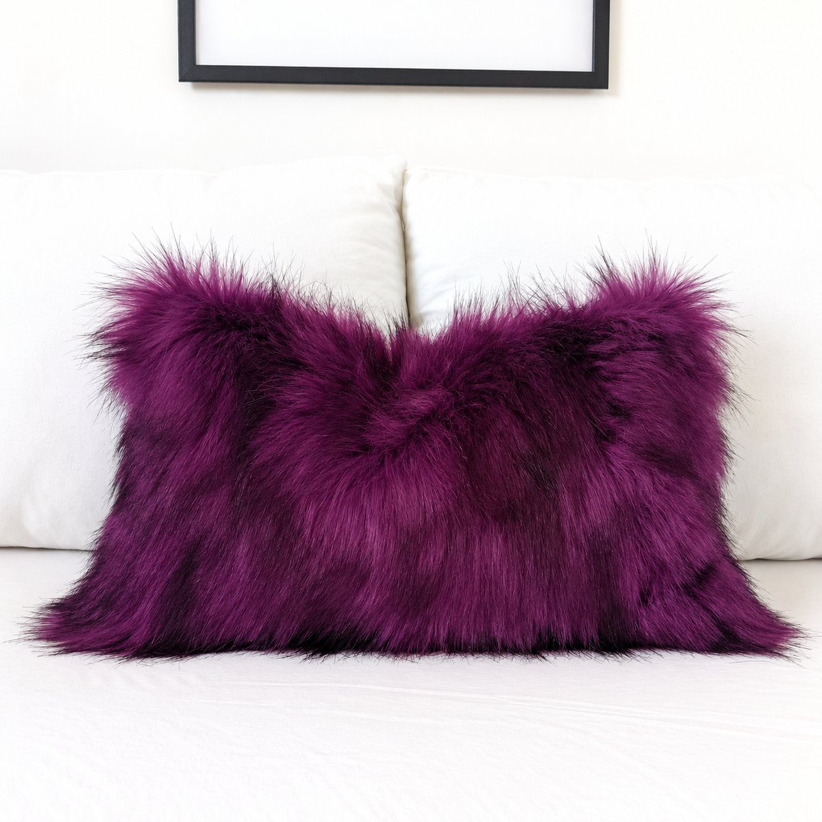 Deep purple faux fur pillow cover with black-tipped long pile, styled on a white sofa for gothic and Halloween home decor