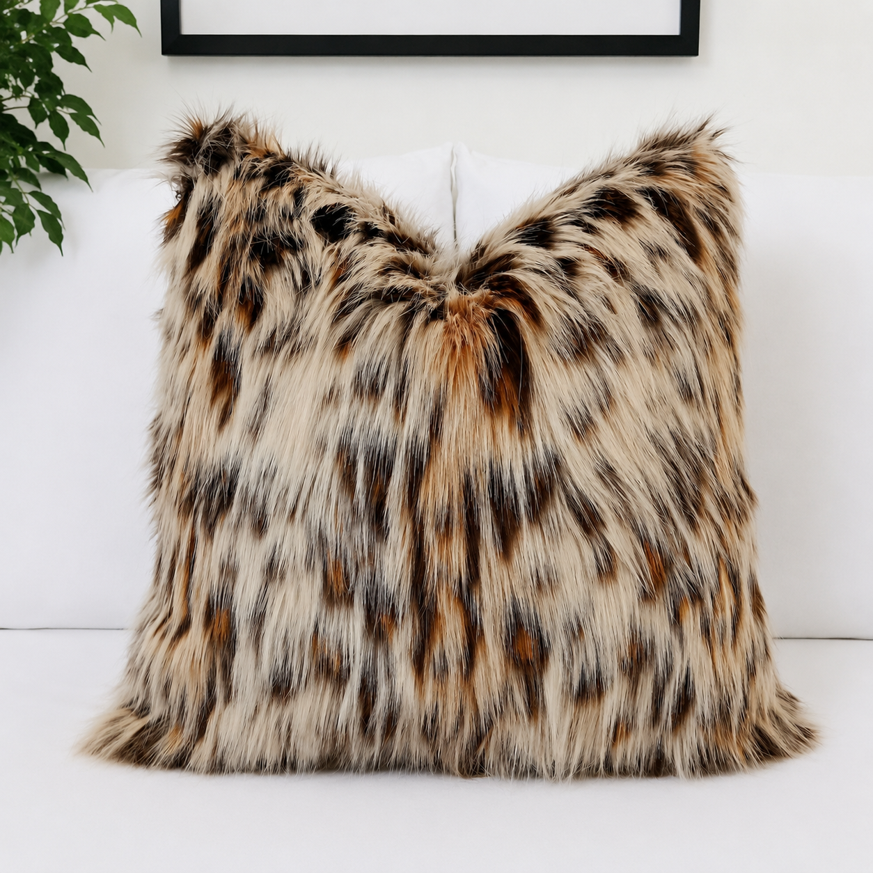 Luxury Leopard Cat faux fur pillow cover with ultra-soft long pile in natural cream, caramel, brown and charcoal tones styled on a white bed.