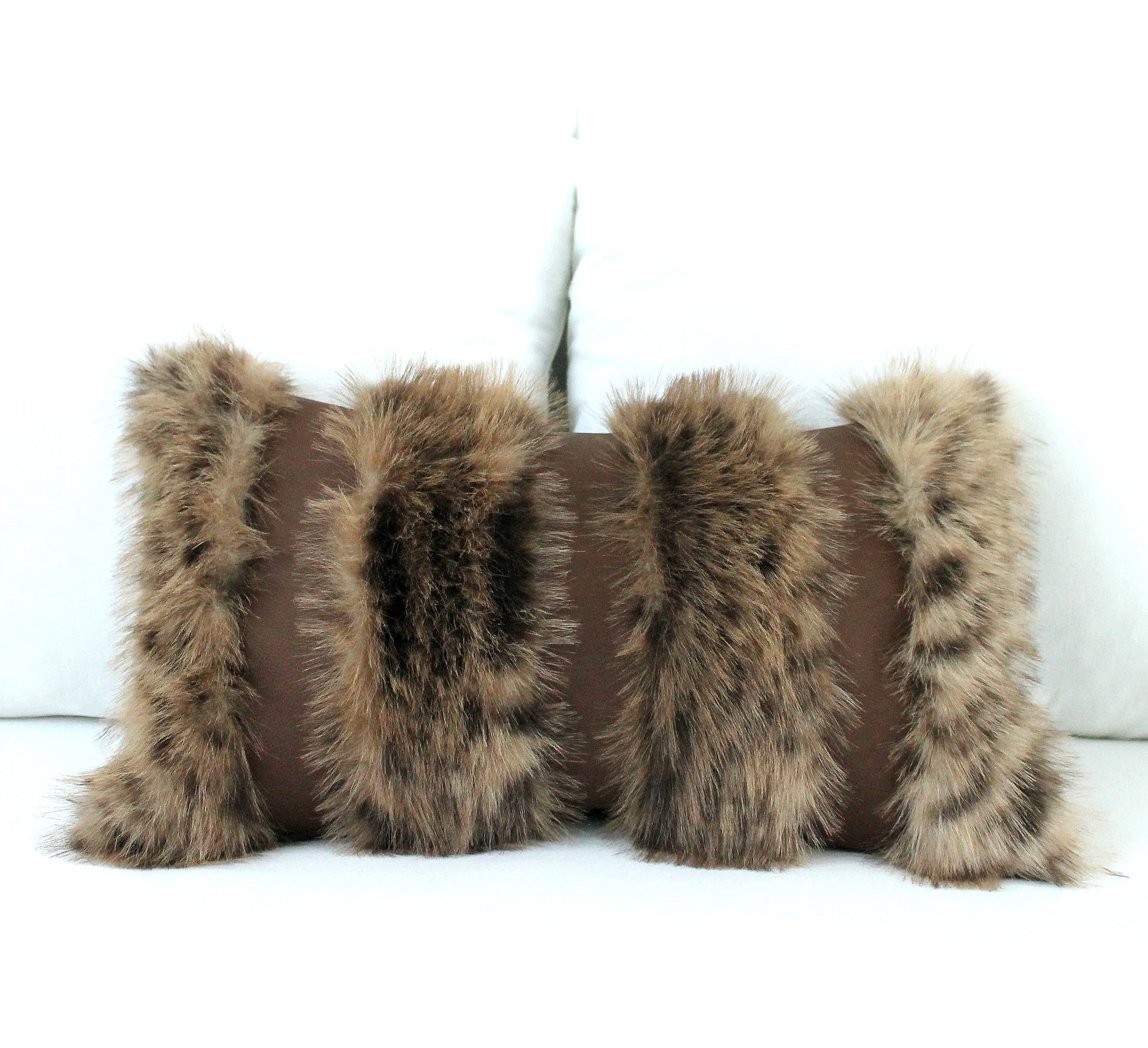 Four brown fur pillows on a white background