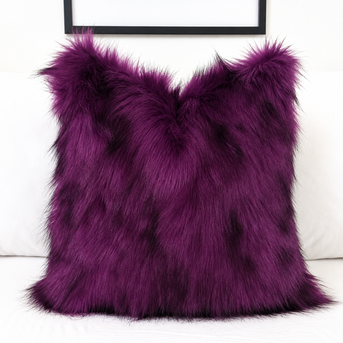 Deep purple faux fur pillow cover with black-tipped long pile, styled on a white sofa for gothic and Halloween home decor