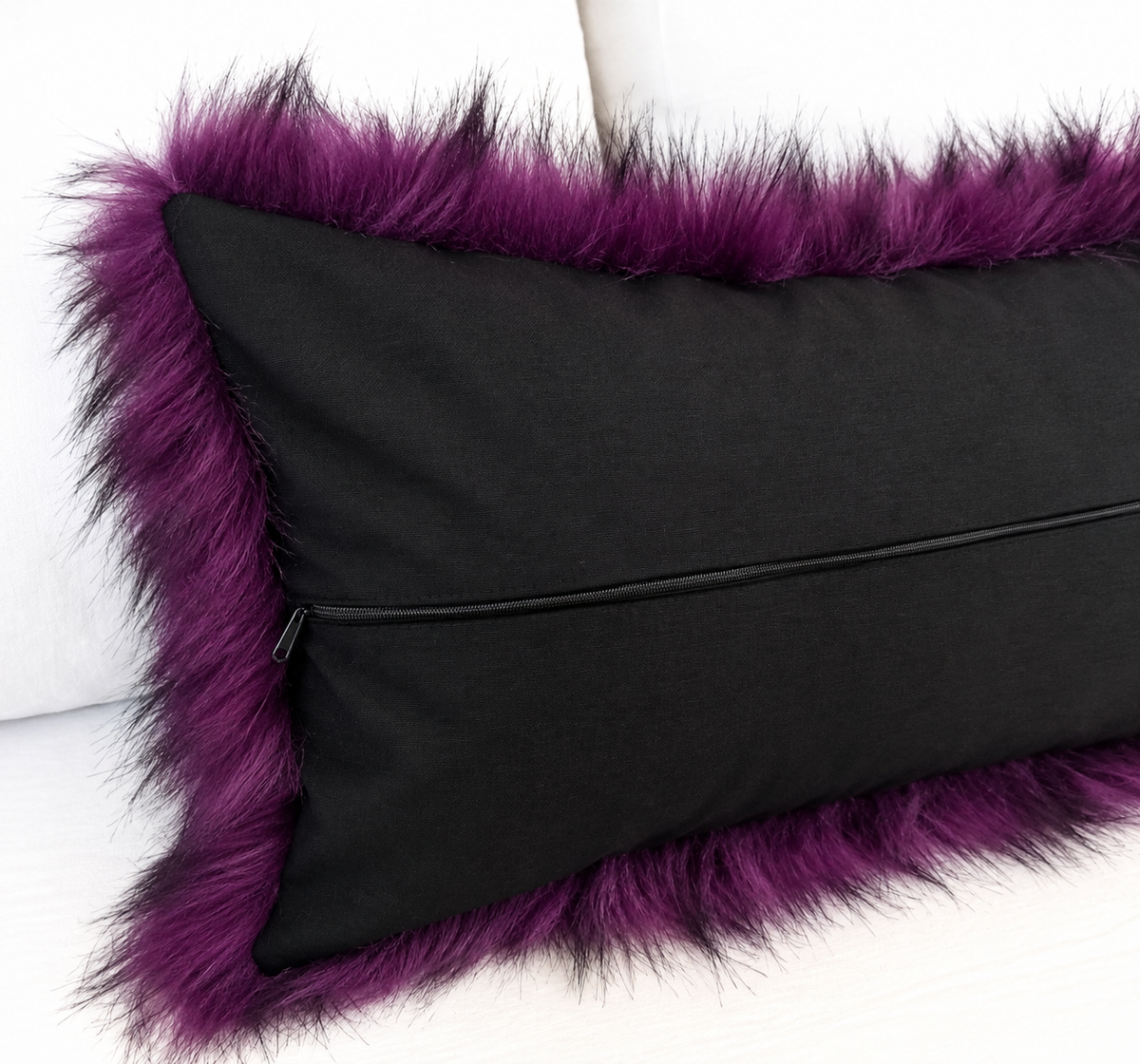 Deep purple faux fur pillow cover with black-tipped long pile, styled on a white sofa for gothic and Halloween home decor
