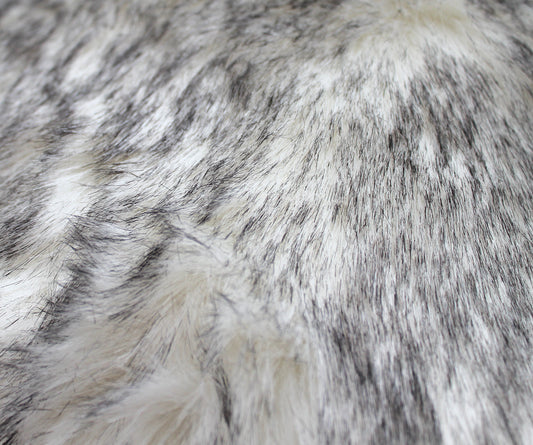 Close-up of premium wolf faux fur fabric showing dense, plush, realistic pile and soft texture.